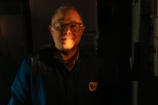Matthew Weisenberger illuminated by the glow of a furnace