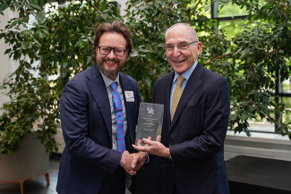 Andrew Pilny accepting an award from Eli Capilouto.