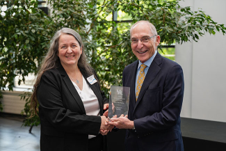 Mary Kay Rayens accepting an award from Eli Capilouto.