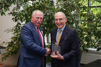 Wayne T. Sanderson accepting an award from Eli Capilouto.