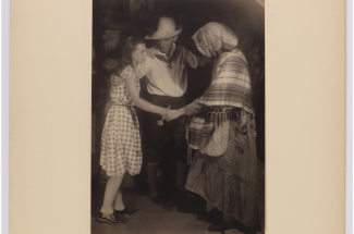 a child in a checkered dress dances with their parents
