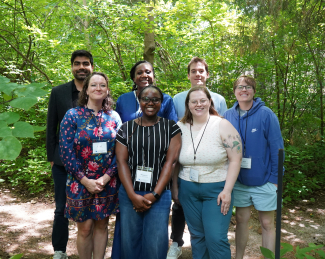 6 Tracy Farmer Scholars and the institute director posing in Mathew's Garden.