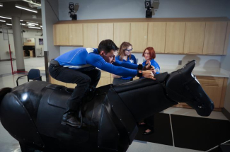 a jockey rides a mechanical horse in the SMRI lab