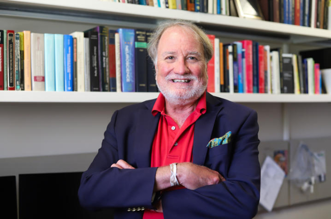 Greg Gerhardt standing in front of a bookshelf